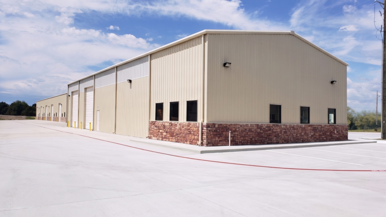 Corner exterior view of a metal building at FM 529 Business Park Office/Warehouse Flex Space Phase I in Houston, TX by Keeton Construction Services, with overhead doors and paved apron