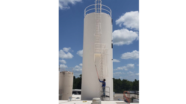 Worker applying surface treatment to a Borden Dairy silo in Houston, TX - Keeton Construction Services