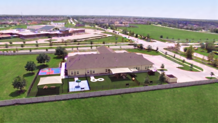 Aerial rear view of the Kiddie Academy Child Care Savannah Lakes building in Rosharon, TX, showing outdoor play areas, built by Keeton Construction Services