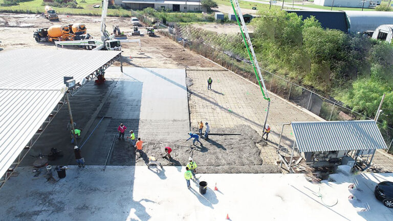 Crew placing concrete at the Alpine Site Services site in Edna, TX, with mixer truck and crane visible, by Keeton Construction Services