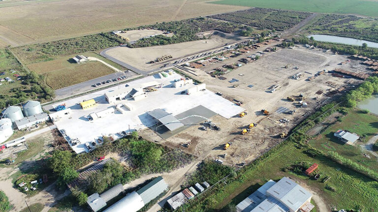 Aerial view of the Alpine Site Services site in Edna, TX during construction, with heavy equipment and buildings visible, by Keeton Construction Services
