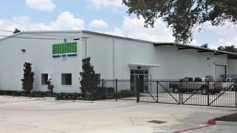 Exterior of the Ewing Irrigation building in Houston, TX — a metal building with signage, fenced parking area, and landscaping — by Keeton Construction Services