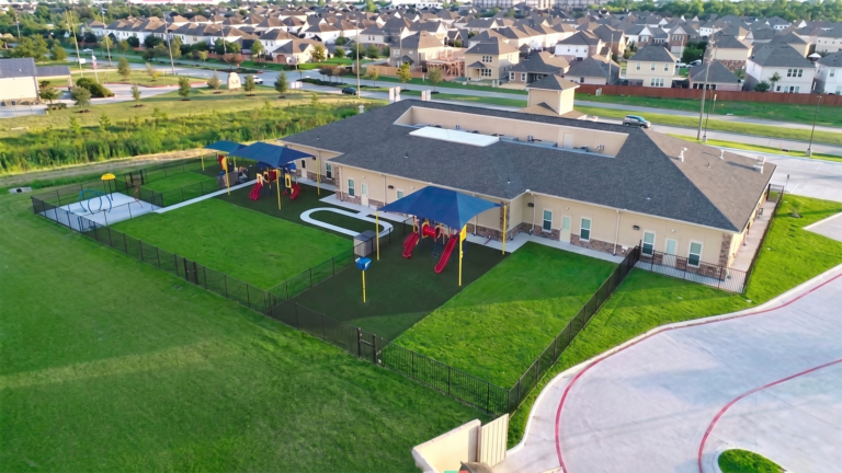 Aerial view of outdoor play area and fenced yard at Kiddie Academy Child Care Mueschke by Keeton Construction Services, Cypress, TX