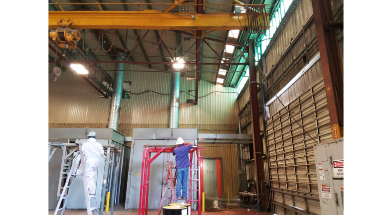 Workers on ladders inside the National Oilwell Varco facility in Houston TX, a Keeton Construction Services project