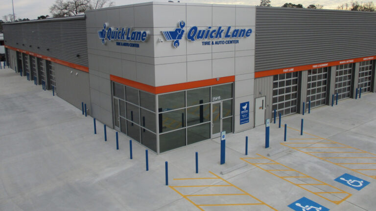 Exterior of the Quick Lane and Auto Care building in Porter, TX built by Keeton Construction Services, showing service bay doors and a paved parking area