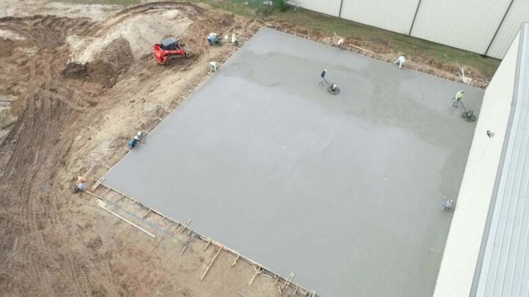 Precision Piping Products concrete slab pour in progress in Houston TX by Keeton Construction Services, aerial view with workers and equipment