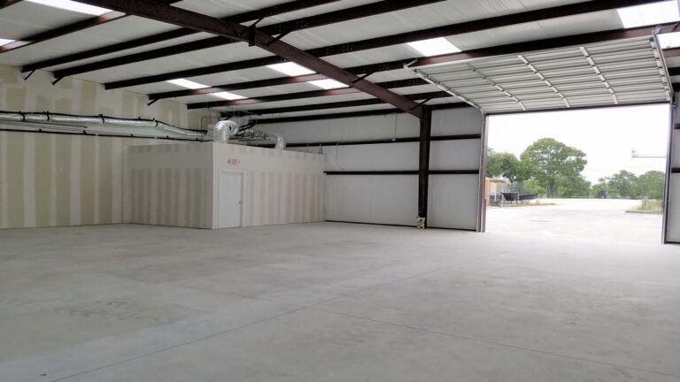 Interior of a warehouse bay at Legacy Business Park in Cypress TX with the overhead door open to the exterior by Keeton Construction Services