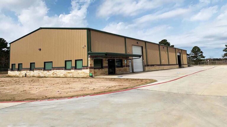 Exterior view of the United Laser Cladding building in Cypress, TX by Keeton Construction Services, with paved apron and bare earth surroundings