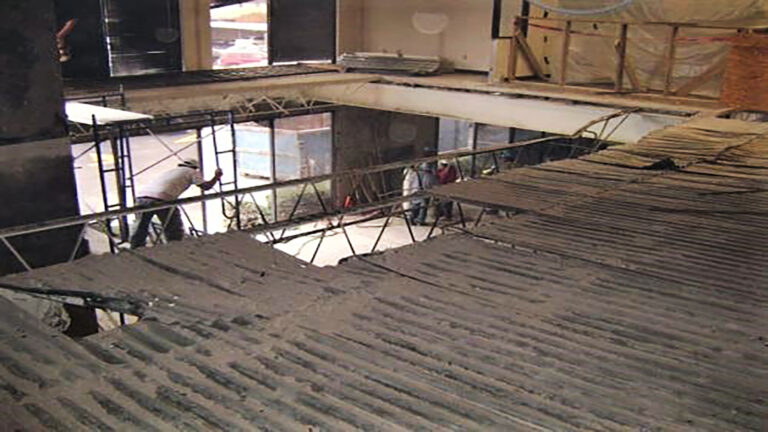 American Spectrum interior during construction, Houston, TX - Keeton Construction Services workers on scaffolding over a structural floor opening