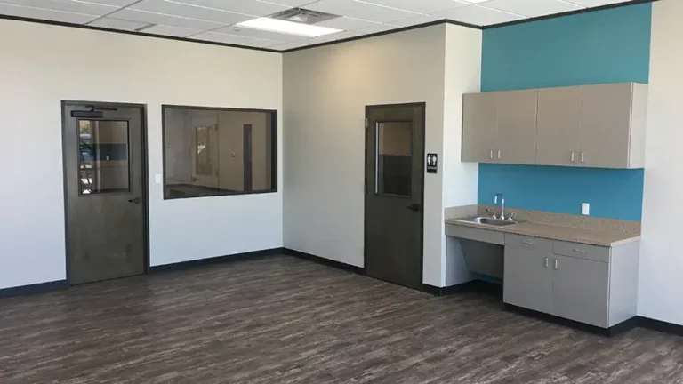 Interior room at The Childhood Center in Katy, TX by Keeton Construction Services, showing cabinets with sink and teal accent wall