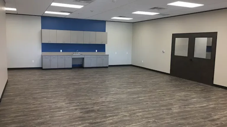 Interior room at The Childhood Center in Katy, TX by Keeton Construction Services, showing cabinets with sink and red accent walls
