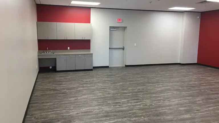 Interior room at The Childhood Center in Katy, TX by Keeton Construction Services, showing wall-mounted cabinets with sink and blue accent wall