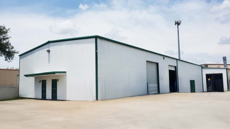 Corner exterior view of the Sherman Roto Tank building in Pearland, TX by Keeton Construction Services, showing roll-up doors and paved yard