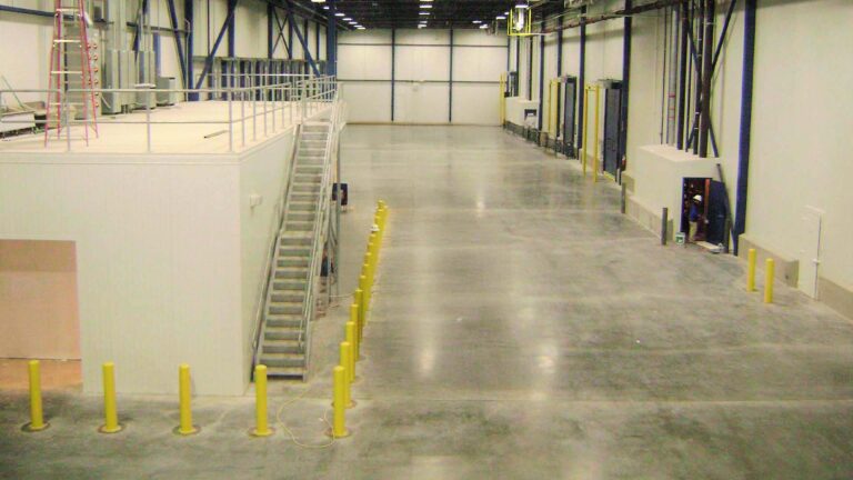Interior warehouse during construction at Jakes Finer Foods in Houston, TX by Keeton Construction Services, showing a mezzanine stair and bollards