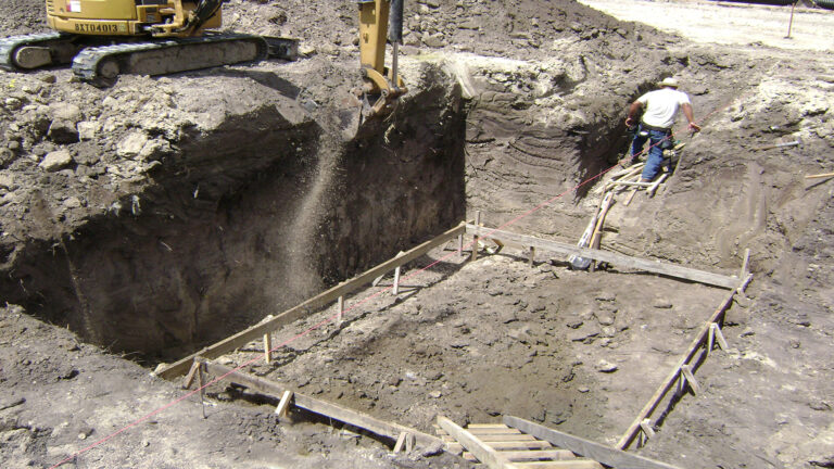 Excavation in progress at Master Rig International in Houston, TX by Keeton Construction Services with an excavator and workers setting foundation forms