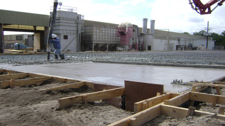 Concrete slab pour in progress at Master Rig International in Houston, TX by Keeton Construction Services with a worker finishing the surface
