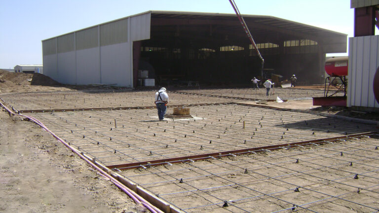 Reinforcing steel grid laid in preparation for a slab pour at Master Rig International in Houston, TX by Keeton Construction Services with workers on site