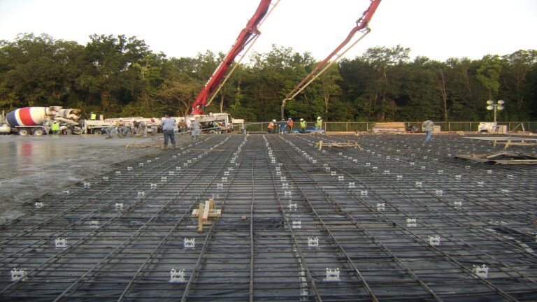 Concrete pour in progress at Master Rig International in Houston, TX by Keeton Construction Services with pump booms, workers, and mixer trucks on site