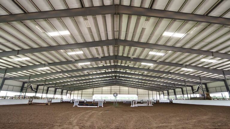 Interior of the Riding Arena metal building by Keeton Construction Services, showing the clear-span roof structure and dirt floor