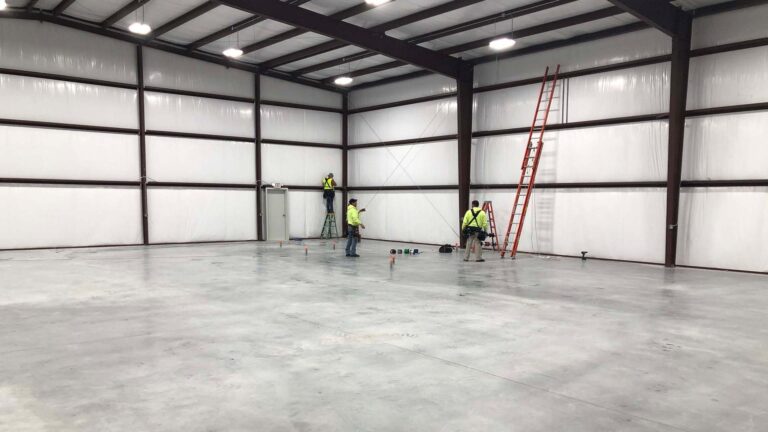 Precision Piping Products interior during construction in Houston TX by Keeton Construction Services, workers on ladders at walls