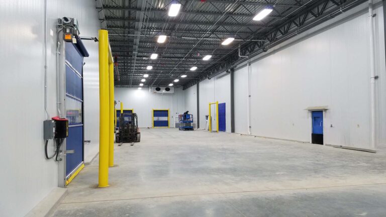 Interior of Renaissance Food Group facility by Keeton Construction Services, Houston, TX, showing warehouse floor, roll-up doors, and overhead lighting