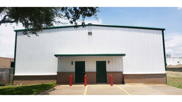 Front entry of the Sherman Roto Tank metal building in Pearland, TX by Keeton Construction Services, with green trim and covered entry