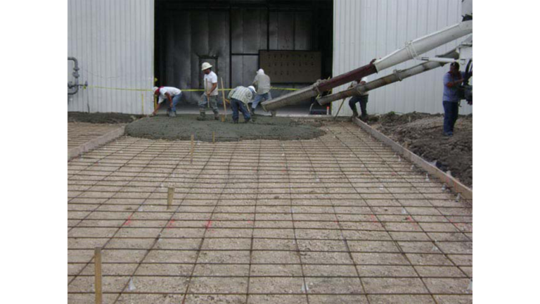 Workers placing a concrete slab during construction at Trelleborg Offshore Engineered Systems in Houston, TX - Keeton Construction Services