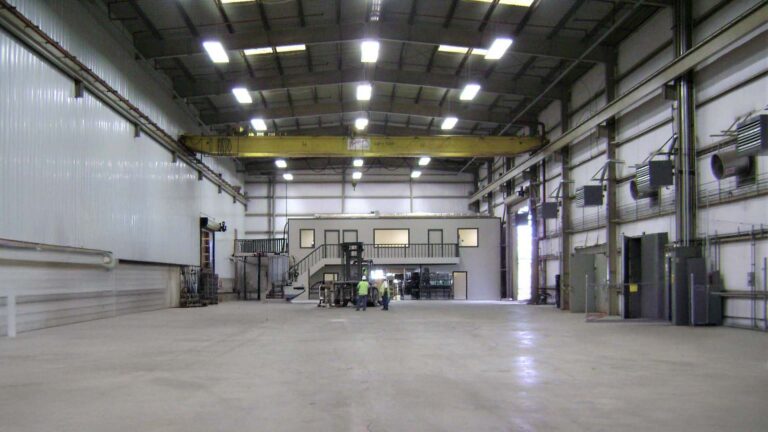 Interior of the Trelleborg Offshore Engineered Systems facility in Houston, TX showing overhead crane and workers, by Keeton Construction Services