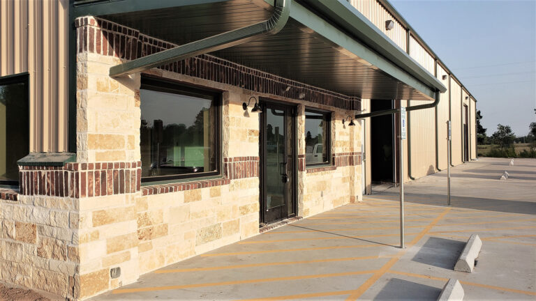 Building entrance detail at United Laser Cladding in Cypress, TX by Keeton Construction Services, showing the covered entry, windows, and masonry base