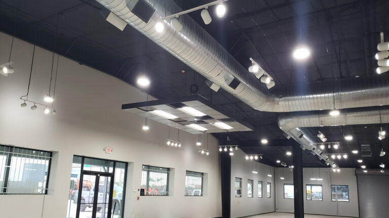 Ewald Kubota Equipment Dealership Houston TX - interior showroom space with exposed ductwork and track lighting, by Keeton Construction Services