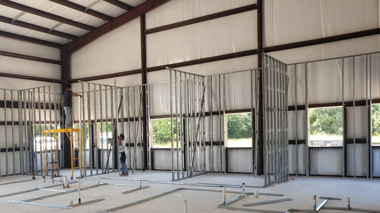 Interior framing in progress at United Laser Cladding in Cypress, TX by Keeton Construction Services, with workers installing metal stud partition walls