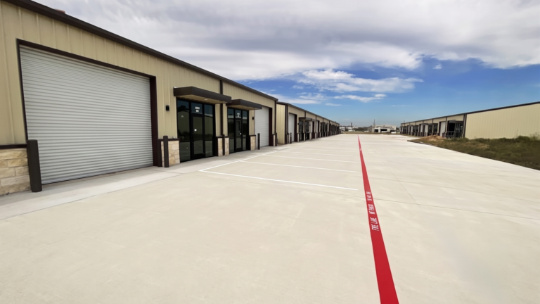 Ground-level exterior view of FM 529 Business Park Phase II in Katy TX showing a row of flex space units and paved drive lane by Keeton Construction Services
