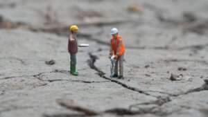 Figurines of Houston construction management professional explaining something to a construction worker