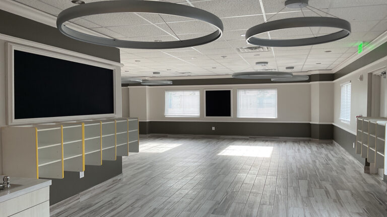 Interior classroom with shelving units and large wall-mounted screen at Prescolaire Early Learning Academy Spring, Keeton Construction Services, Spring, TX