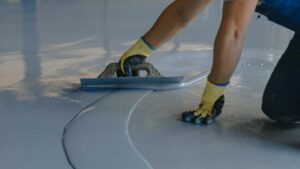 Industrial painting contractor applying non-slip coating to floor surface