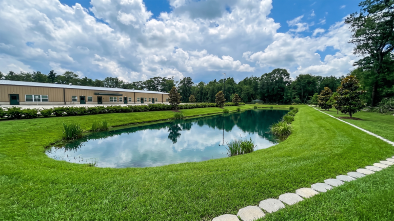 Little Texans Day Care Center exterior view with a retention pond and lawn in the foreground, Conroe, TX - Keeton Construction Services