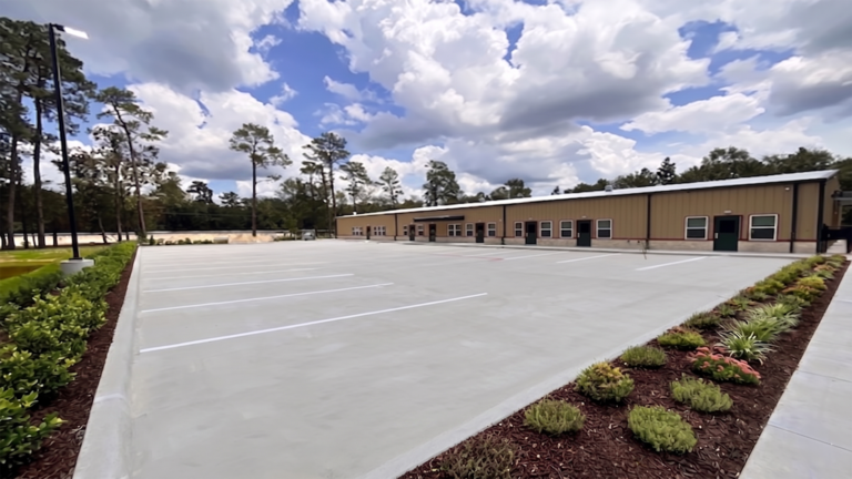 Little Texans Day Care Center parking area with landscaping and the building exterior in the background, Conroe, TX - Keeton Construction Services