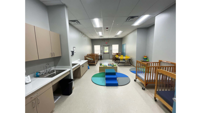 Little Texans Day Care Center interior infant room with cribs, built-in cabinetry, a sink and a play area, Conroe, TX - Keeton Construction Services