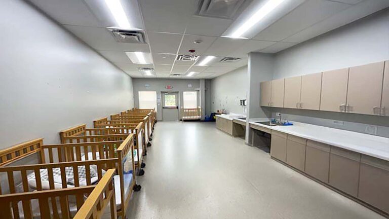 Little Texans Day Care Center interior room with rows of cribs and built-in cabinetry with a sink, Conroe, TX - Keeton Construction Services