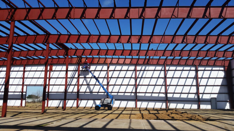 American Petroleum interior during construction with aerial lift and wall panels being installed, Houston, TX - Keeton Construction Services