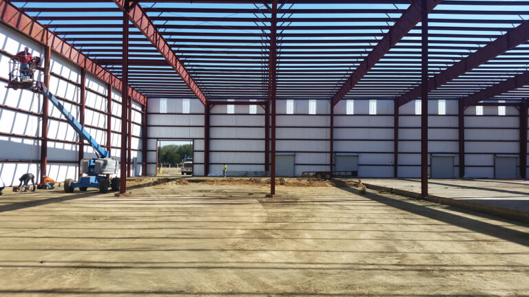 American Petroleum interior during construction with aerial lift and workers installing wall panels, Houston, TX - Keeton Construction Services
