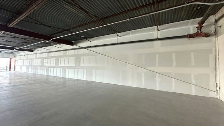 Interior view of Fairmont Retail Center showing floor, interior walls, and overhead piping, Pasadena TX - Keeton Construction Services
