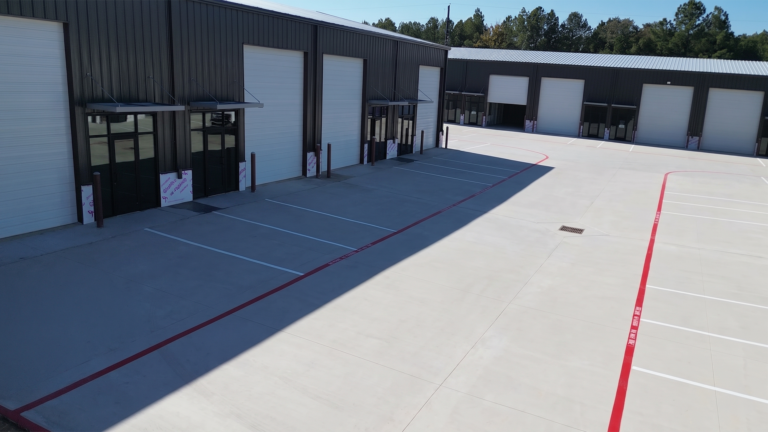 Ground-level view of overhead doors and glass entries on a metal building at Spring Cypress Business Park in Tomball TX, Keeton Construction Services