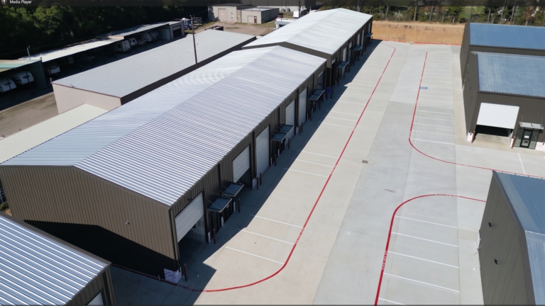 Elevated view along a row of metal buildings at Spring Cypress Business Park in Tomball TX showing overhead doors and drive aisle, Keeton Construction Services
