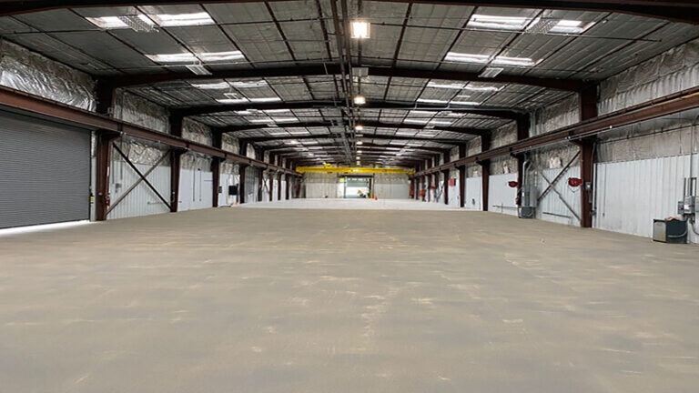 Interior of the Oceaneering International Inc facility in Houston, TX, by Keeton Construction Services, showing a wide open floor and steel structure
