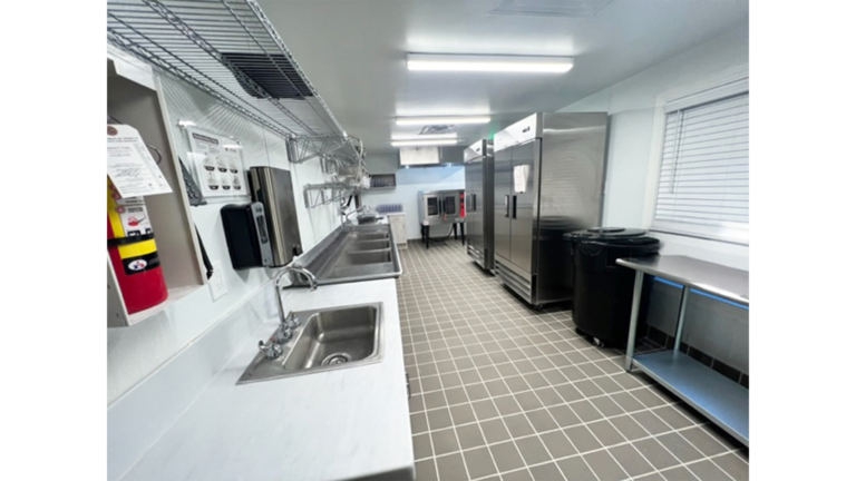 Commercial kitchen interior with counters and refrigeration equipment at Prescolaire Early Learning Academy Katy, Keeton Construction Services, Katy TX