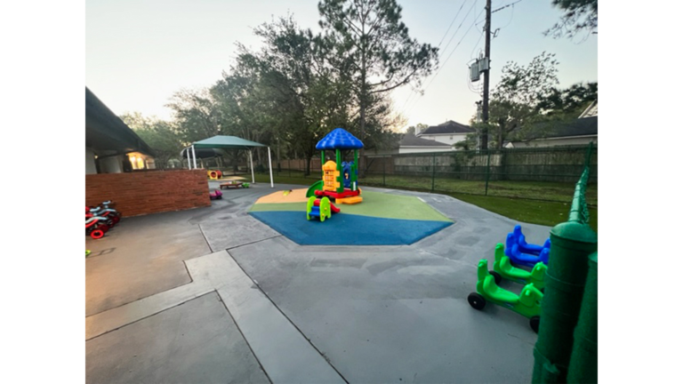 Outdoor play area with playground equipment on paved surface at Prescolaire Early Learning Academy Katy, Keeton Construction Services, Katy TX
