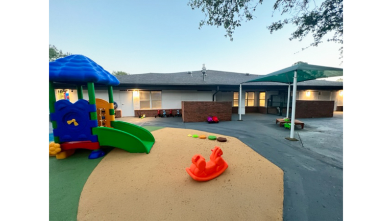 Outdoor play area with playground equipment and building exterior in background at Prescolaire Early Learning Academy Katy, Keeton Construction Services, Katy TX