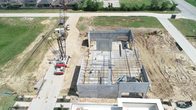 Aerial view of Gourmet Foods during construction in Houston, TX with walls up and a crane on site, by Keeton Construction Services