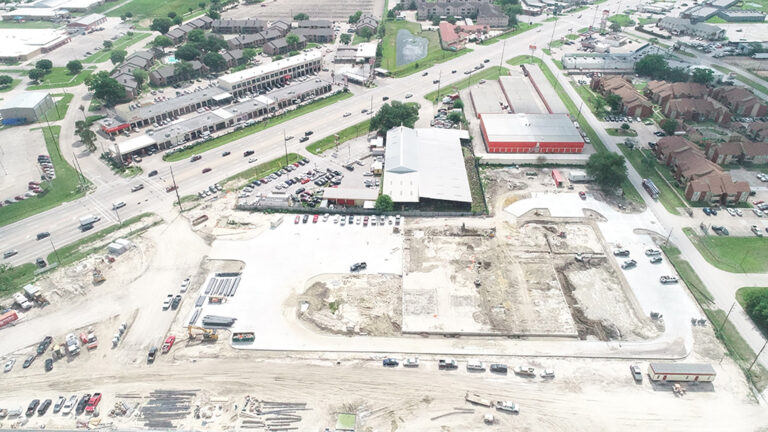 Aerial view of the Gourmet Foods site in Houston, TX with graded ground and a building in the background, by Keeton Construction Services